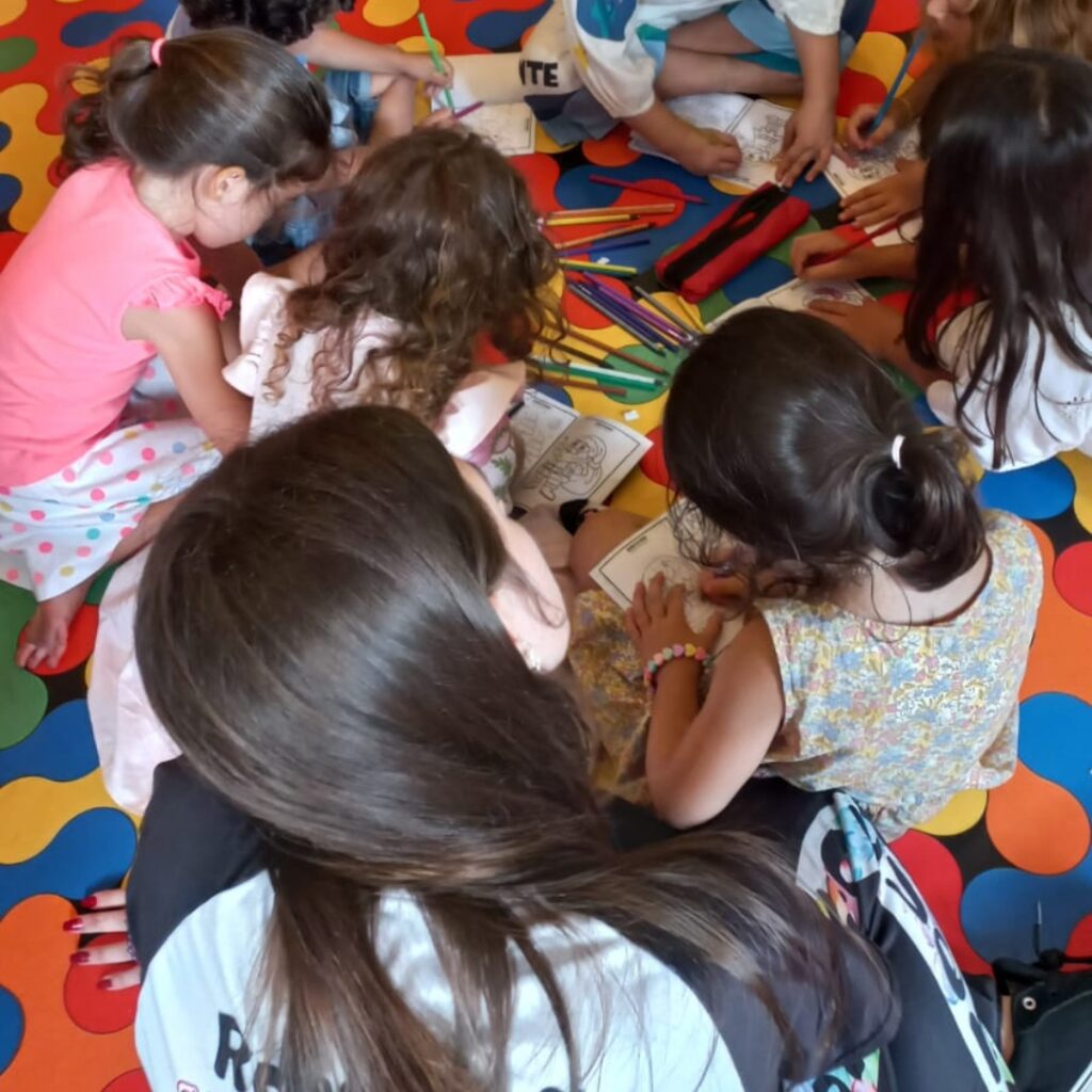 Crianças pintando desenho durante a oficina recreativa da festa infantil